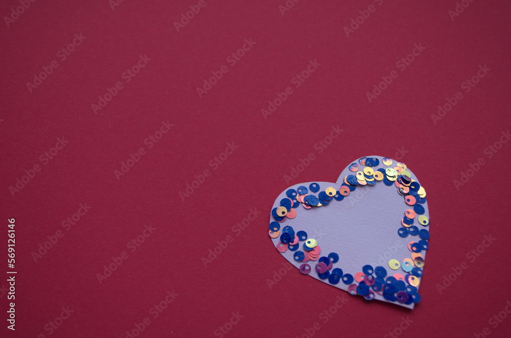 Heart shaped frame made of shiny sequins on a blue background. Festive texture for Valentines Day, Mothers Day, Womens Day Heart shaped frame made of shiny sequins on a blue background. Festive texture for Valentines Day, Mothers Day, Womens Day
