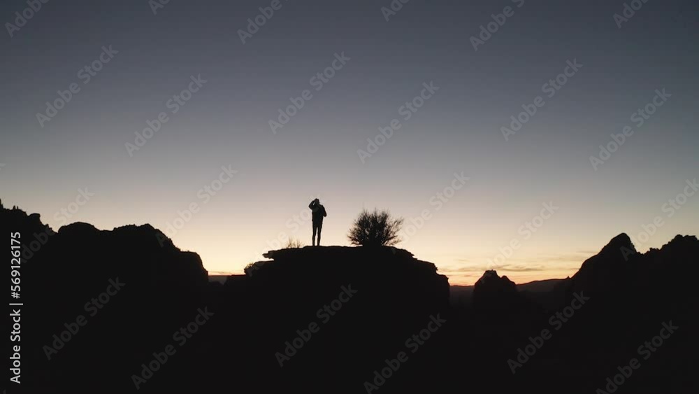 Silhouette of a man on a hill, contemplating life as he looks out of a vast desert sunset
Silhouette of a man on a hill, contemplating life as he looks out of a vast desert sunset