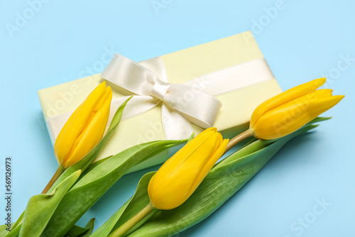 Fototapeta Naklejka Na Ścianę i Meble -  Beautiful tulip flowers and gift for Women's Day celebration on blue background