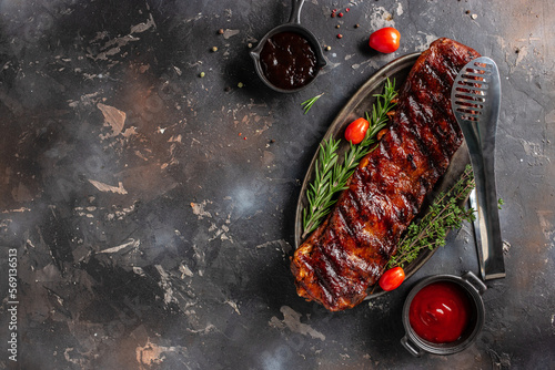 Barbecue pork spare ribs on a dark background. American Spare Ribs in BBQ Sauce. Restaurant menu, dieting, cookbook recipe top view