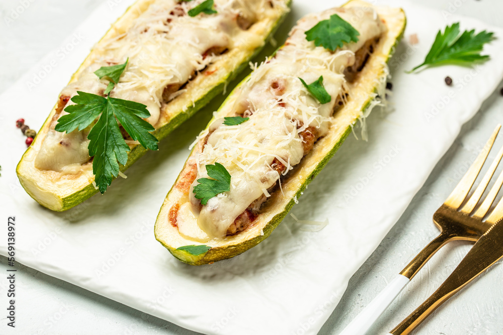 Zucchini stuffed with minced meat and cheese on a light background. Restaurant menu, dieting, cookbook recipe top view