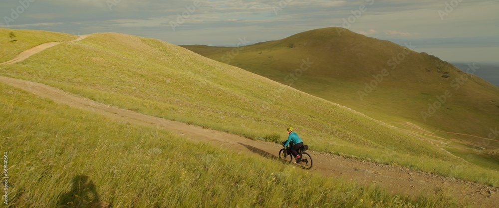 Φωτογραφία The woman is ride on top of a hill with the mountain lake in background the picturesque valley