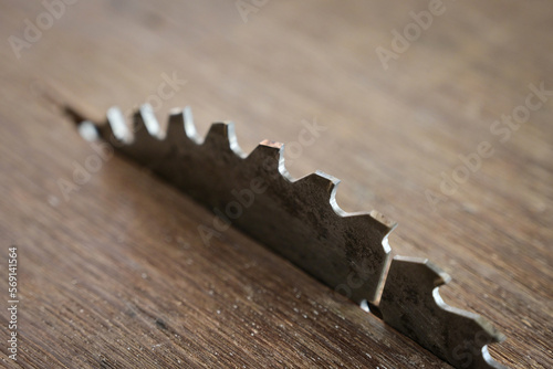sharp metal saw on wood plank texture background, construction machine