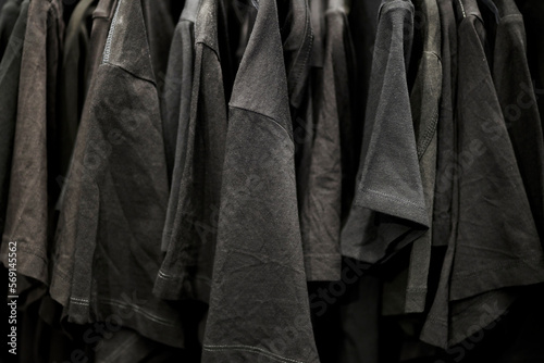 black men's t-shirts on hangers in a clothing store. Men's black t-shirts hanging on hangers in the store. Black t-shirt hanging on a hanger in a clothing store