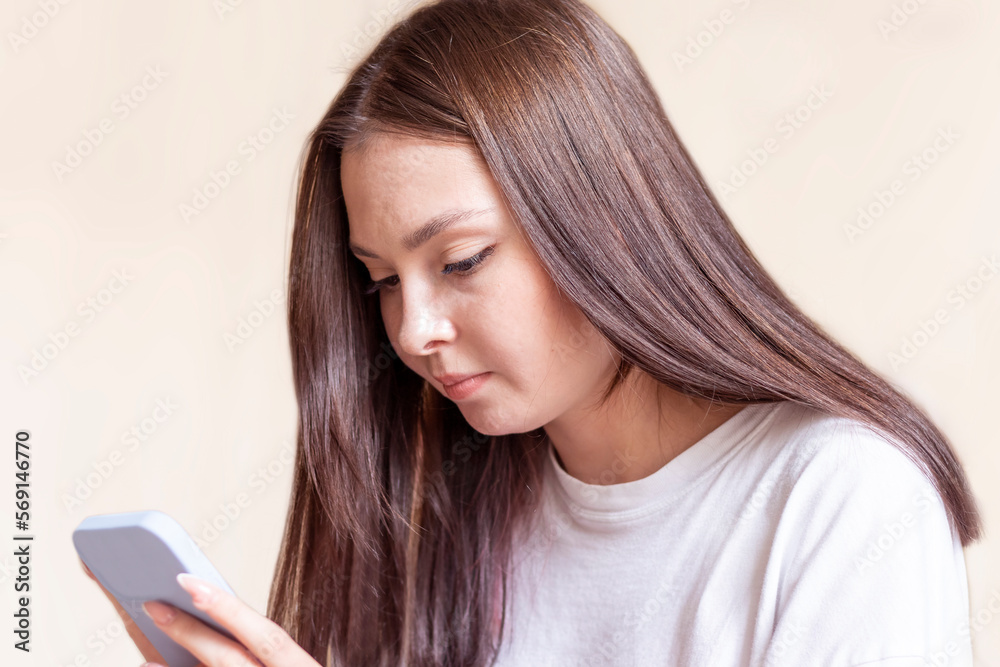 A young woman uses a mobile phone. Close-up. A young woman uses a mobile phone. Close-up.