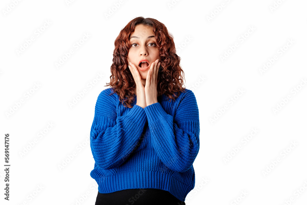 Beautiful woman wearing blue knitted sweater standing isolated over white background looking excited holding her mouth opened, hands on head. Can't believe what hear. Beautiful woman wearing blue knitted sweater standing isolated over white background looking excited holding her mouth opened, hands on head. Can't believe what hear.