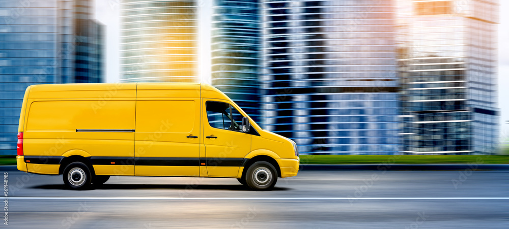 Yellow Van driving on a city road at sunset in front of a modern cityscape