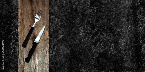 Topview of Set of Fork, Knife and Cutting Board on Dark Background
