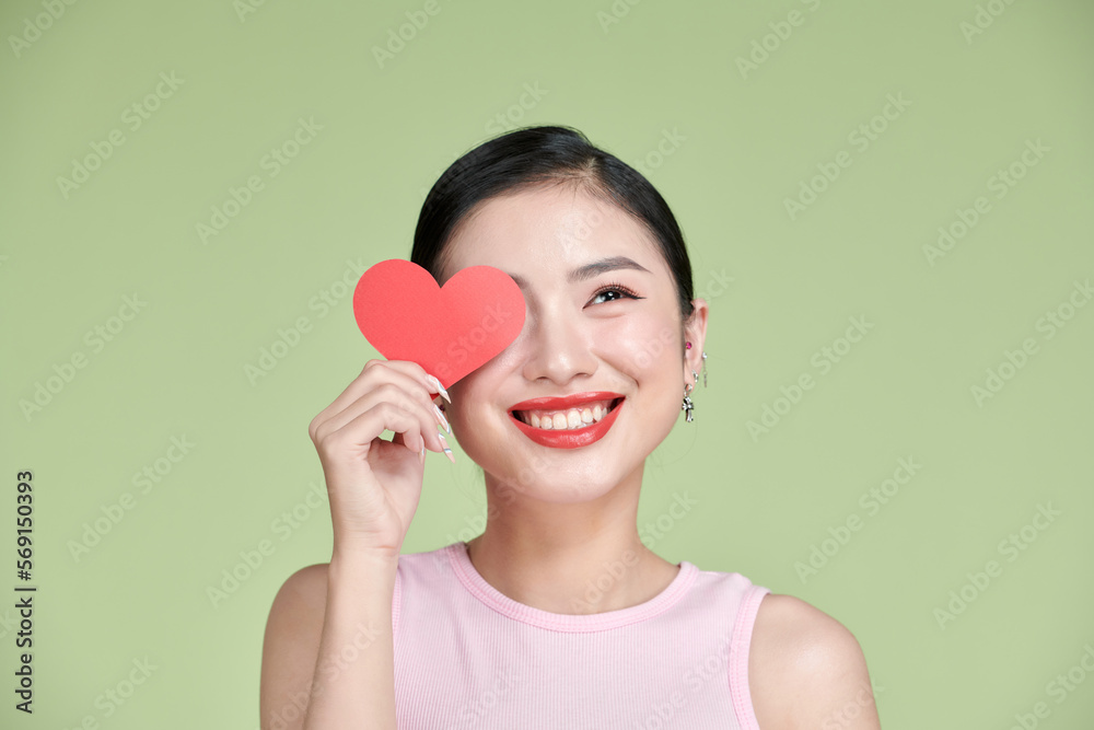 Love symbol. Beautiful girl holding a heart, office manager concept shot Love symbol. Beautiful girl holding a heart, office manager concept shot