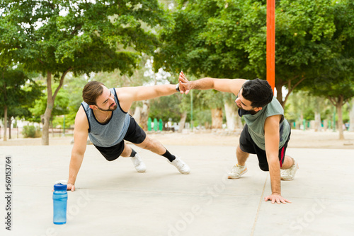 Active friends exercising with push ups outdoors