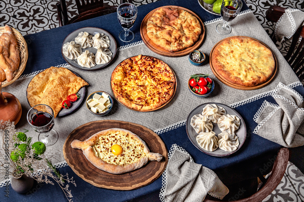 Traditional Georgian Adjara khachapuri, manti and on the table. Food Table Celebration Delicious Party Meal Concept. Traditional Georgian Adjara khachapuri, manti and on the table. Food Table Celebration Delicious Party Meal Concept.