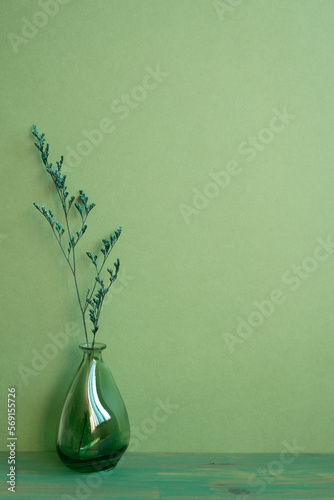Obraz na płótnie Glass vase of dry flower on wooden table. green wall background. home interior, minimal, copy space w salonie