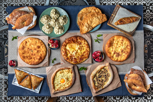 Traditional Georgian Adjara khachapuri, manti and Kolkh khachapuri on the table. Food Table Celebration Delicious Party Meal Concept. 