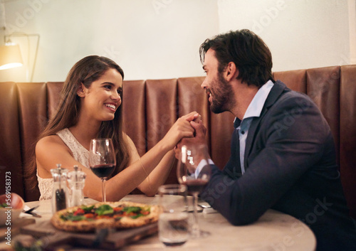 Food, wine and love, couple holding hands at table on valentines day date with smile, pizza and drinks. Date night, man and woman with smile, valentine celebration and happy relationship together.