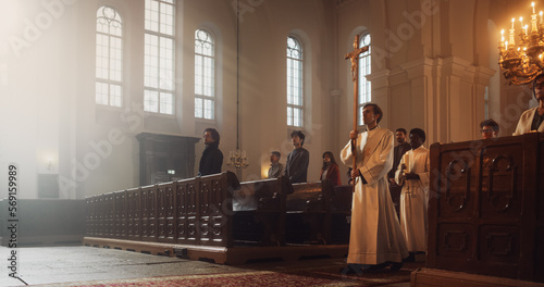 Liturgical in Grand Church: Majestic Procession Of Ministers And Priests Walking with Processional Cross. Congregation Stands In Reverence, Christians Rejoice In Ceremony of Mass in The Lord's Glory