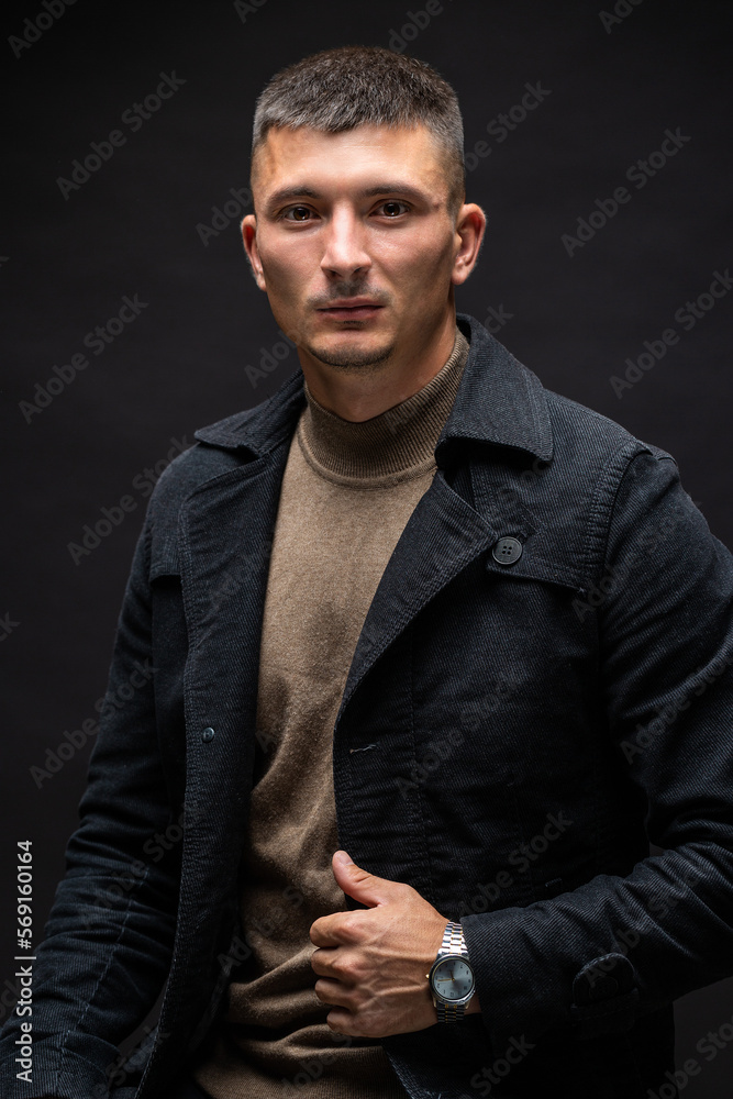 Young successful stylish man. Classical portrait of a businessman dressed in a jacket with a watch on his hand. Young successful stylish man. Classical portrait of a businessman dressed in a jacket with a watch on his hand.