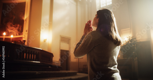 Side View: Christian Woman Getting on her Knees and Starting to Pray in a Church. She Seeks Guidance From her Religious Faith and Spirituality. Spirit of Christianity and Belief in the Goodness of God