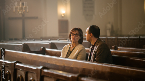 Obraz na plátně Portrait of Young Man and Old Woman Talking and Discussing While Sitting in a Church