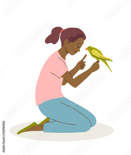 Girl plays and teach parrot to talk. Pet care concept.