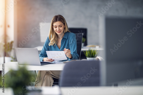 Young confident smiling businesswoman, successful entrepreneur working in modern office