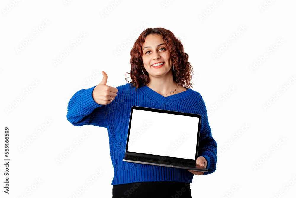 Naklejka premium Young woman wearing blue pullover sweater isolated over white background holding a laptop with a blank white mockup screen, smiles at the camera and gives a thumbs-up sign.