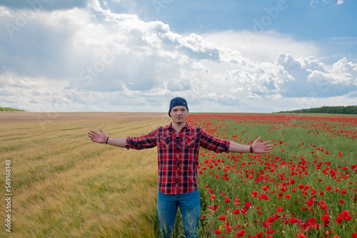 Young Man wearing Red for Valentines day  posing in Flower Field with Poppies. Love and Romance