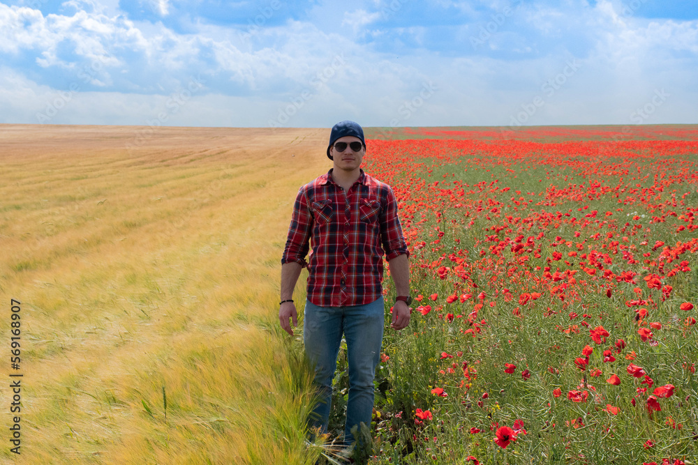Young Man wearing Red for Valentines day, posing in Flower Field with Poppies. Love and Romance
