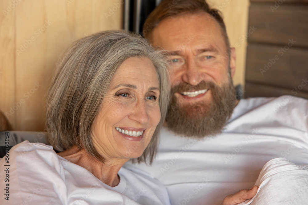 Mature couple staying in bed and looking happy Mature couple staying in bed and looking happy