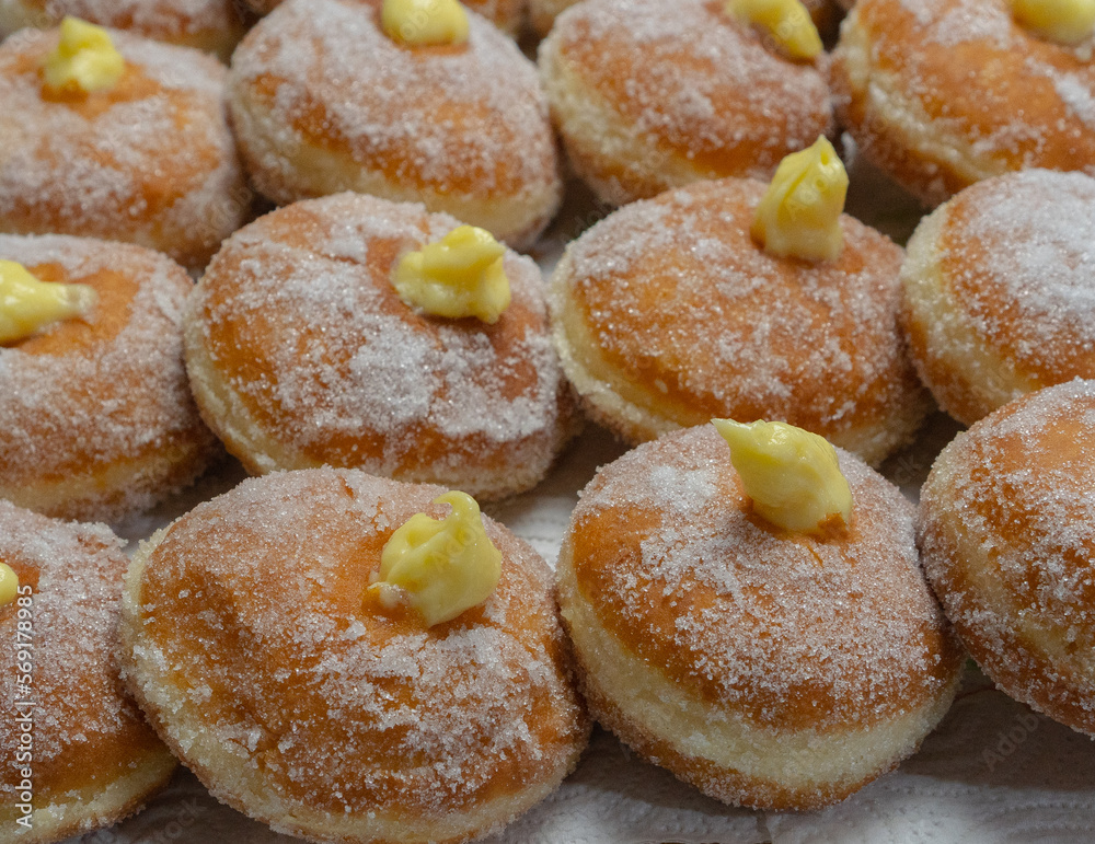 Homemade fried donuts filled with custard and seasoned with a veil of sugar

