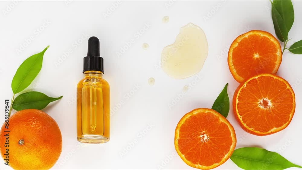 Close-up of sliced juicy tangerine and citrus anti-aging liquid serum with vitamin C and bio collagen on white background. Nearby is sample of texture of drops of serum. Flat lay, mockup, top view Close-up of sliced juicy tangerine and citrus anti-aging liquid serum with vitamin C and bio collagen on white background. Nearby is sample of texture of drops of serum. Flat lay, mockup, top view