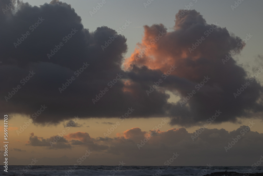Gray thick clouds over the sea at sunset