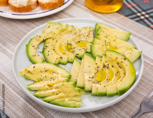 Fototapeta Naklejka Na Ścianę i Meble -  ripe avocado pulp cut into pieces sprinkled with lemon juice on a plate