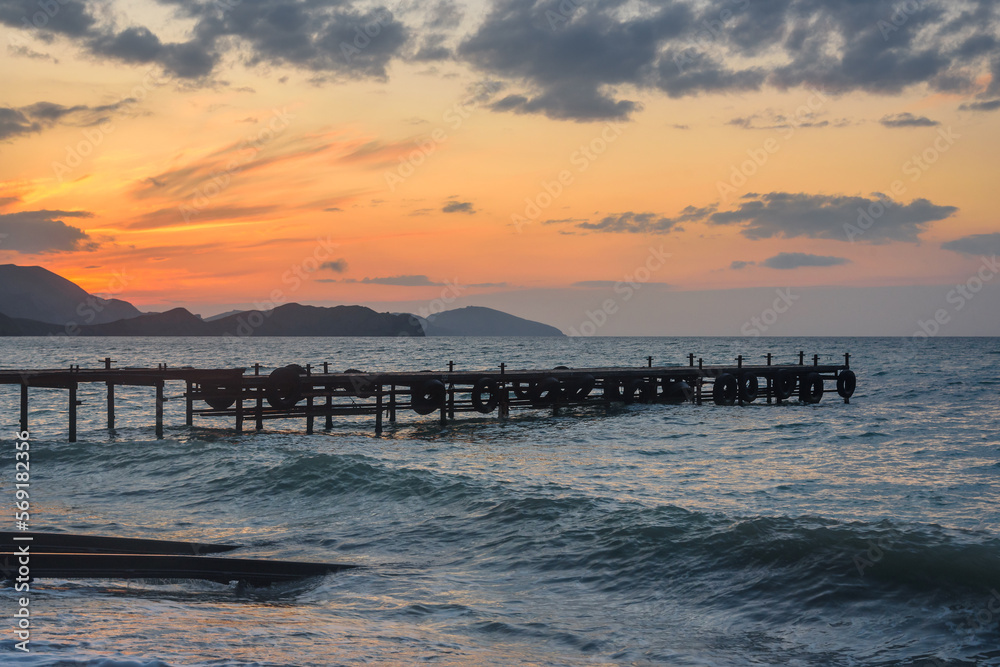Wooden pier in sea at sunrise. Koktebel. Crimea
