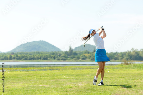 Golfer sport course golf ball fairway. People lifestyle woman playing game golf and hitting go on green grass river and mountain background.  Asia female player game shot in summer
