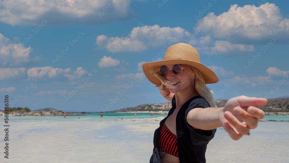 Portrait of happy woman with straw hat smiling on the beach on Crete island Greece.