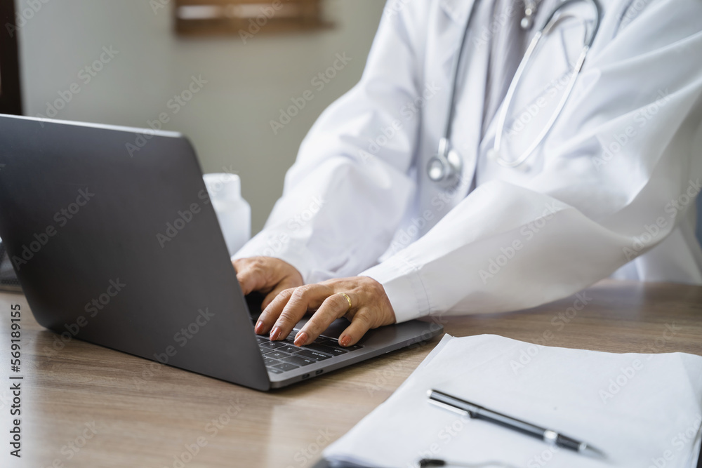 Doctor working with laptop computer and writing on paperwork. in the room. Doctor working with laptop computer and writing on paperwork. in the room.