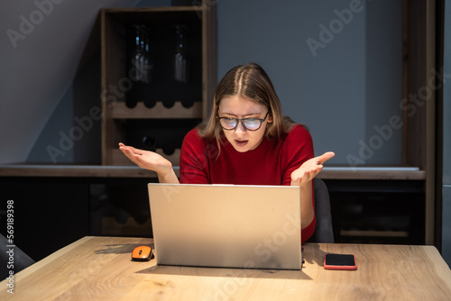 Concentrated young beautiful businesswoman working on laptop in modern home office. Expert female finishing her job for internet company marketing ideas and solutions