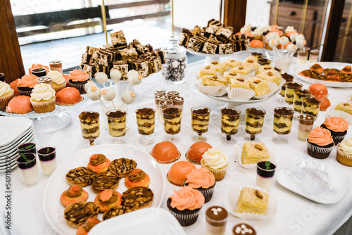 Candy bar with desserts for celebrating birthday, baptism, wedding. Table with cake, sweets, candies, dessert.