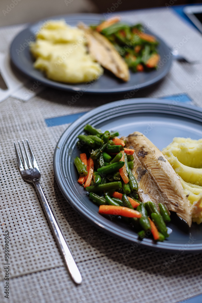 Potatoes with fish and sauce and vegetables on the table Potatoes with fish and sauce and vegetables on the table