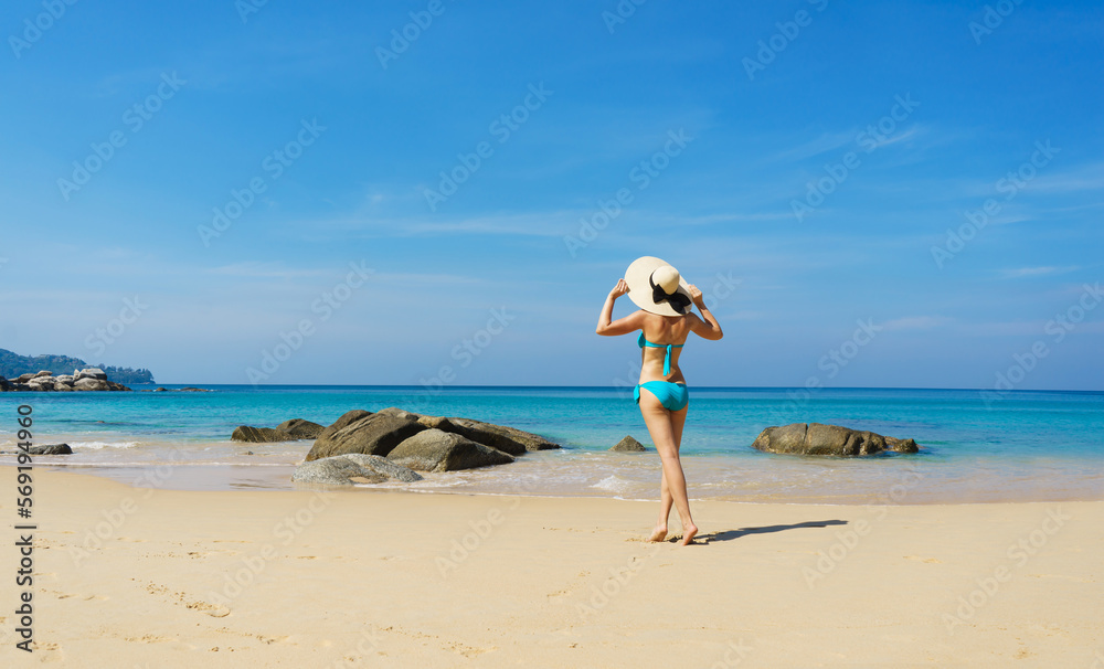 A beautiful woman in a swimsuit posing on a Thai beach at summer. Concept of holiday, vacation, traveling and resort. A beautiful woman in a swimsuit posing on a Thai beach at summer. Concept of holiday, vacation, traveling and resort.