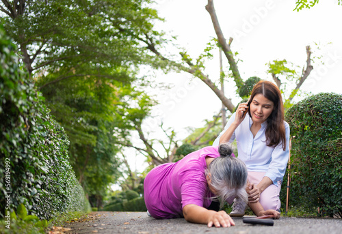 Asian senior woman fell down on lying floor because faint and limb weakness and pain from accident and woman came to help support and call emergency. Concept of old elderly insurance and health care