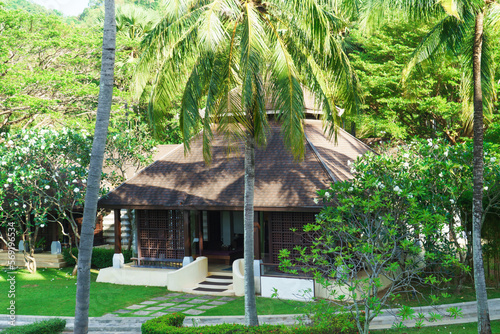 Traditional Bungalow in the Asian garden. Exotic plants and flowers, beautiful landscape. © Acronym