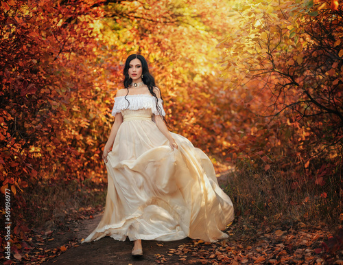 Art photo fantasy woman queen walking in gothic autumn forest, white vintage style dress. Girl princess beauty face long wavy hair, elegant sexy bare open shoulders. Red orange yellow color dark tree.