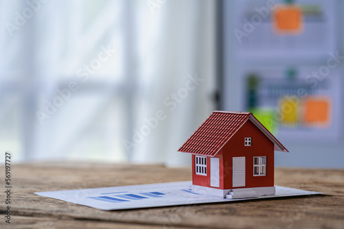 red wooden house real estate business concept on financial papers