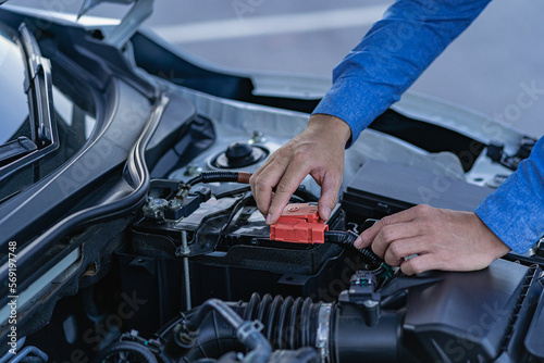Man checking his car engine, professional mechanic working on car engine, car repair service. The concept of checking the readiness of the car before leaving.