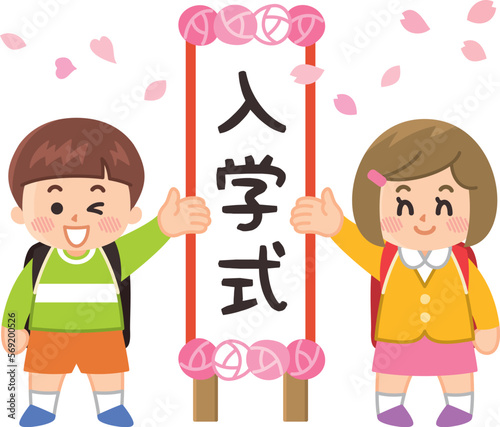 入学式の看板の前に立つ小学生