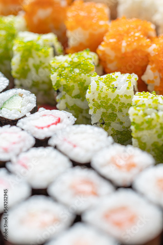 maki sushi rolls with green and orange fish roe, cumber and surimi 