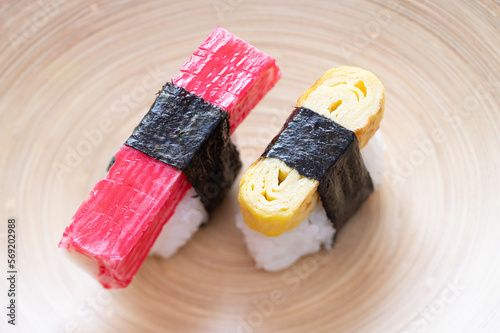 Nigiri sushi with surimi and omelet on a bamboo dish