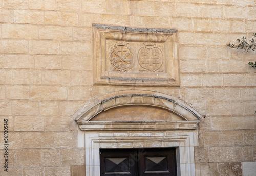 Religious symbols carved in stone above the entrance to the Maronite church of St. Antonius in old part of Nazareth, northern Israel photo