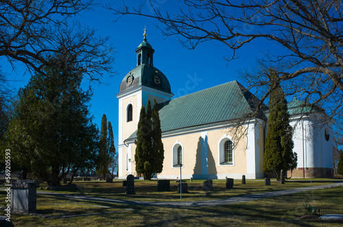 Church and graveyard garden in Scandinavia in spring sunny day, medieval church in Skultuna, Sweden photo